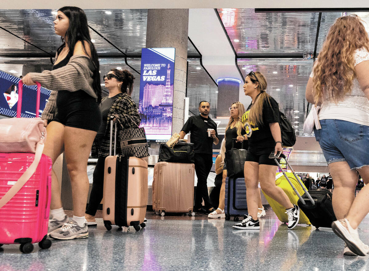 Pasajeros que llegan se dirigen a la zona de reclamo de equipaje en la Terminal 1 del Aeropuert ...