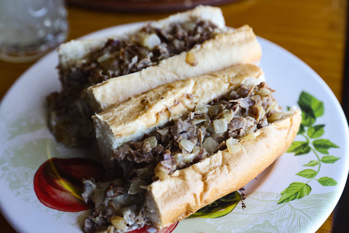 El sándwich clásico Philly Cheesesteak, un panecillo Liscio's con cebolla frita picada y ques ...