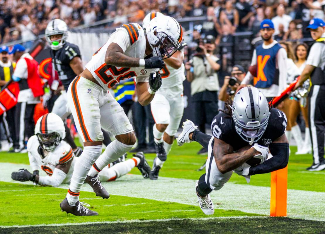 El wide receiver de los Raiders DJ Turner (19) recibe un golpe del cornerback de los Cleveland ...