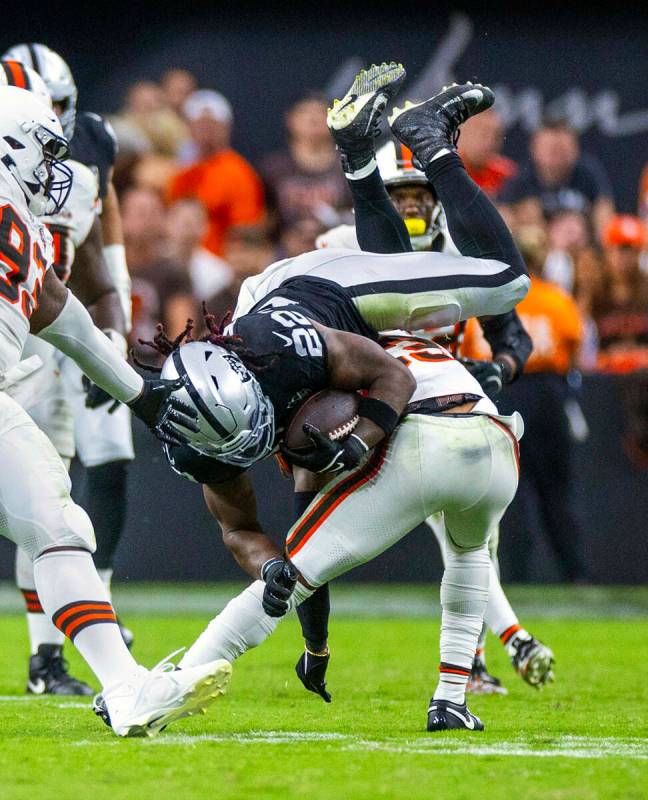 El running back de los Raiders Alexander Mattison (22) es derribado en carrera por el cornerbac ...