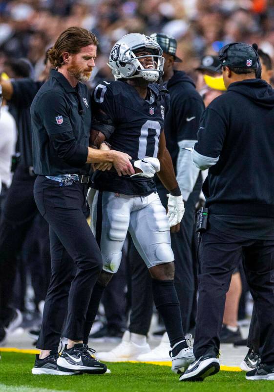 El cornerback de los Raiders Jakorian Bennett (0) es asistido fuera del campo con una posible l ...