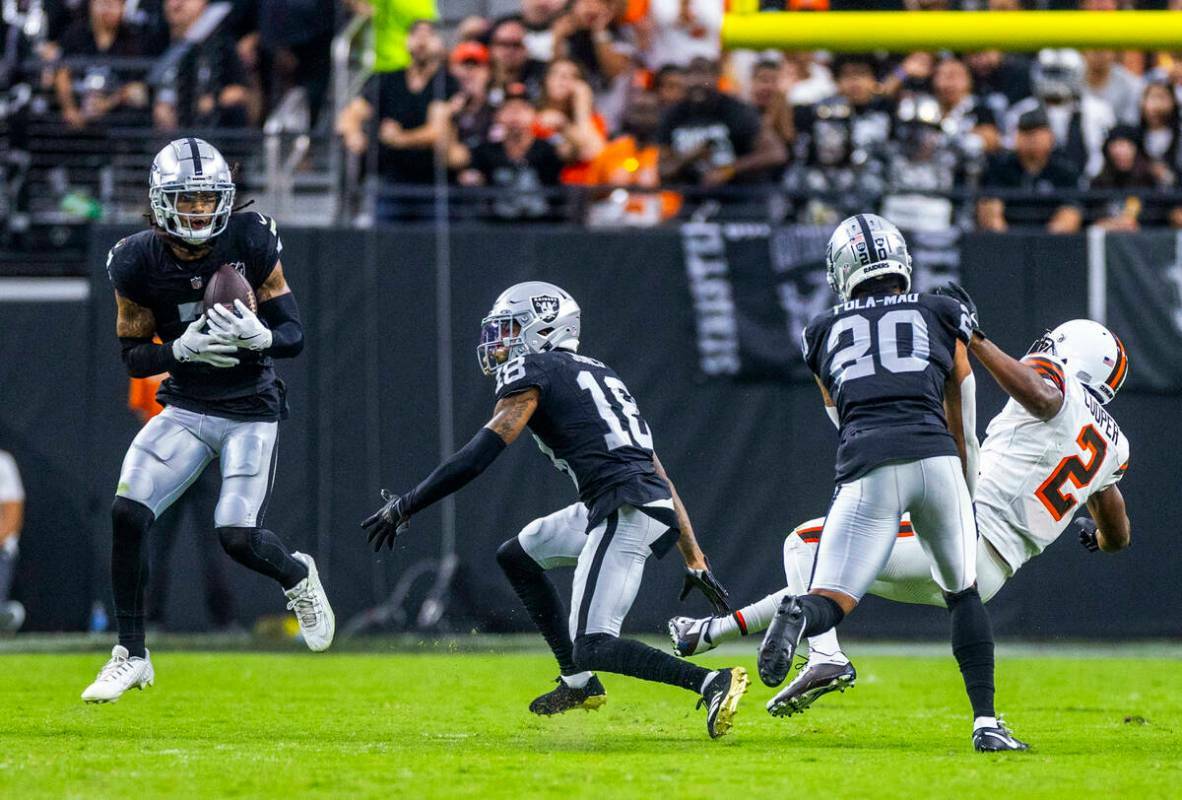 El safety de los Raiders Tre'von Moehrig (7) observa una intercepción mientras el safety Isaia ...