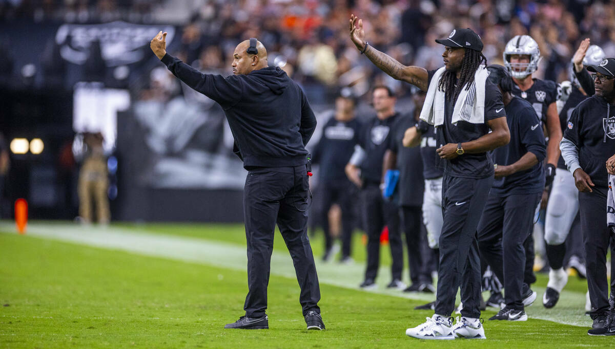 El entrenador de los Raiders, Antonio Pierce, y el wide receiver Davante Adams (17) señalan a ...