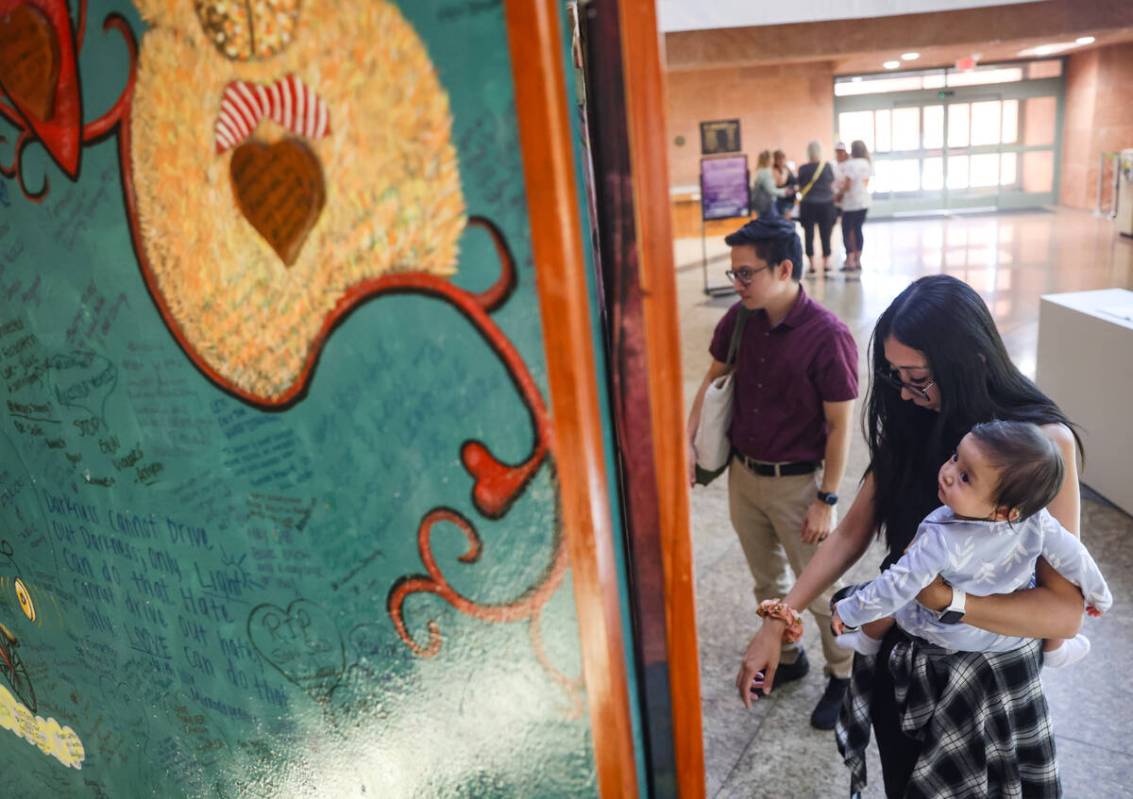 Alec Madriaga, de izquierda a derecha, observa las pinturas en exhibición con su esposa Joan M ...