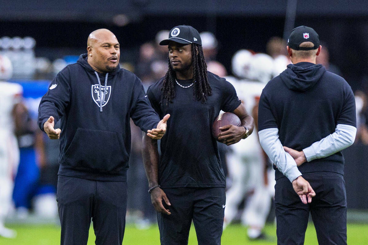 El entrenador de los Raiders, Antonio Pierce, charla con el wide receiver Davante Adams (17) du ...