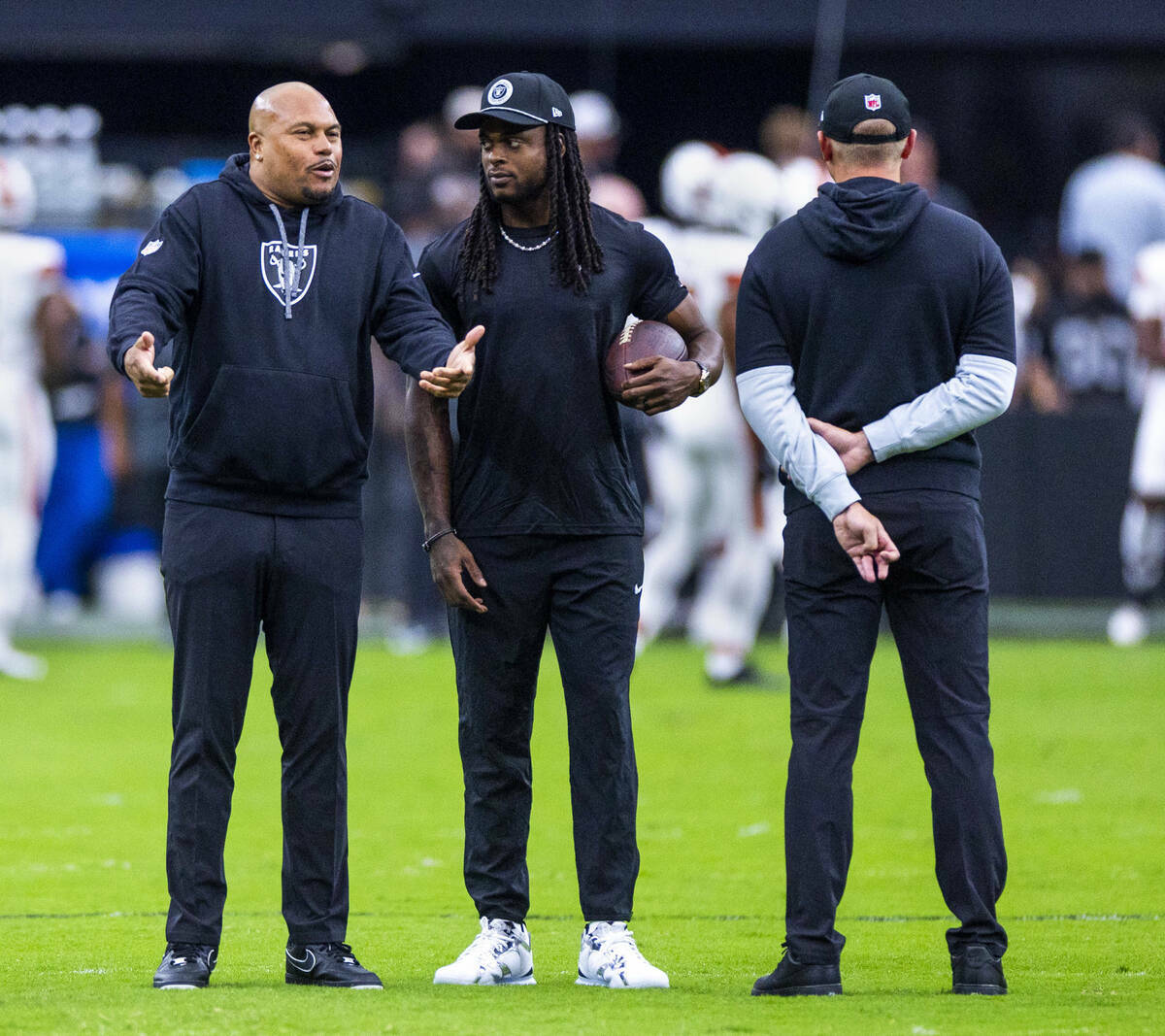 El entrenador de los Raiders, Antonio Pierce, charla con el wide receiver Davante Adams (17) du ...