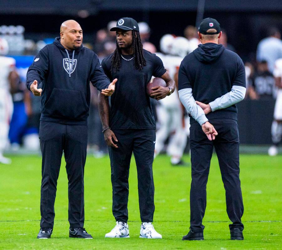 El entrenador de los Raiders, Antonio Pierce, charla con el wide receiver Davante Adams (17) du ...