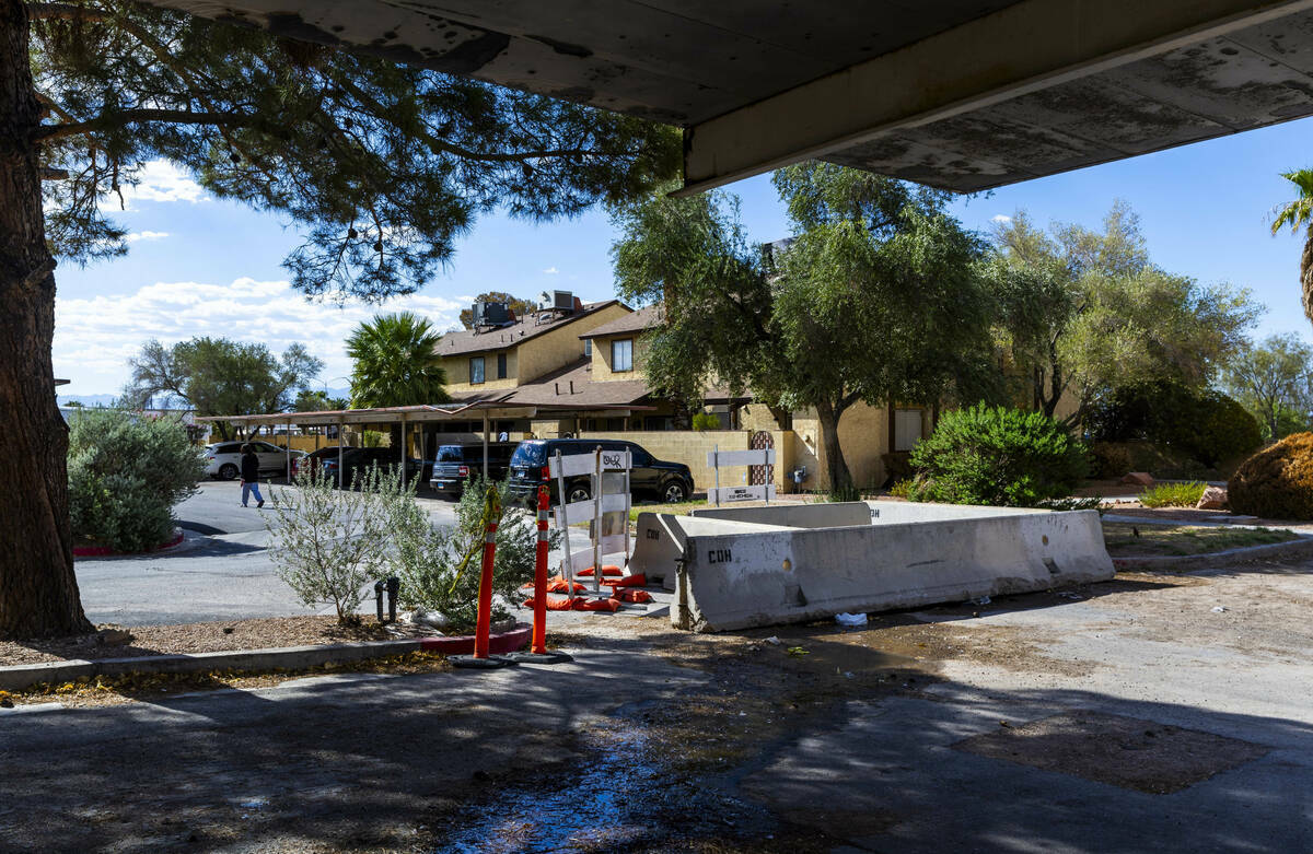 Un residente rodea un área con barricadas donde el agua que se filtra causó un socavón en un ...