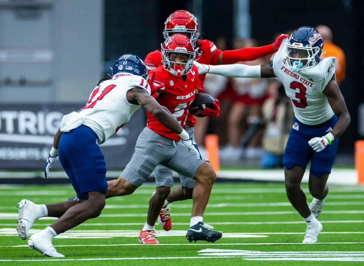 El wide receiver de UNLV, Jacob De Jesús (21), intenta aplicar un stiff arm sobre el defensive ...