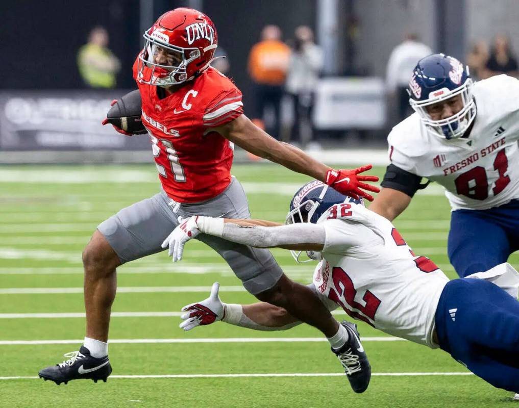 El wide receiver de UNLV, Jacob De Jesús (21), esquiva al defensive back de Fresno State, Dean ...