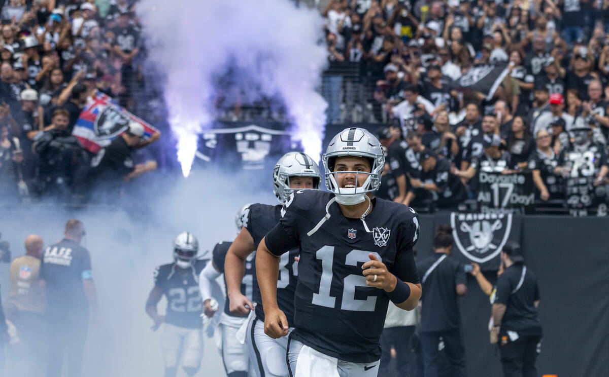 El quarterback de los Raiders Aidan O'Connell (12) y sus compañeros corren hacia el campo desd ...