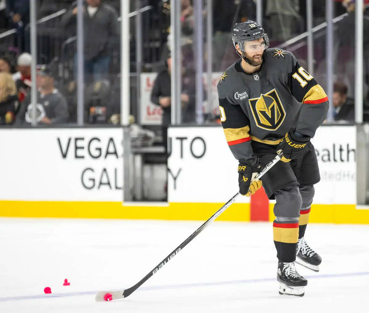 El center de los Golden Knights, Nicolas Roy (10), intenta disparar un pato rosa que fue lanzad ...