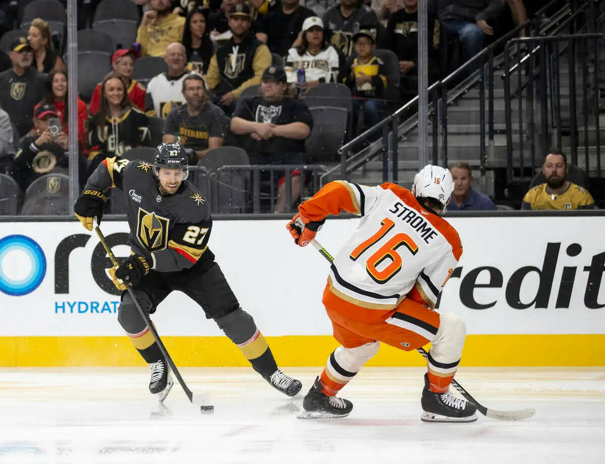 El defenseman de los Golden Knights, Shea Theodore (27), mantiene el puck alejado del center de ...