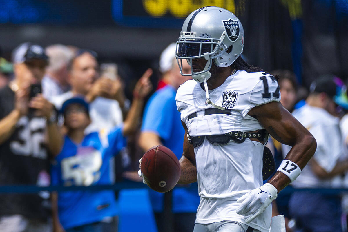 El wide receiver de los Raiders, Davante Adams (17), corre con el balón mientras calientan par ...