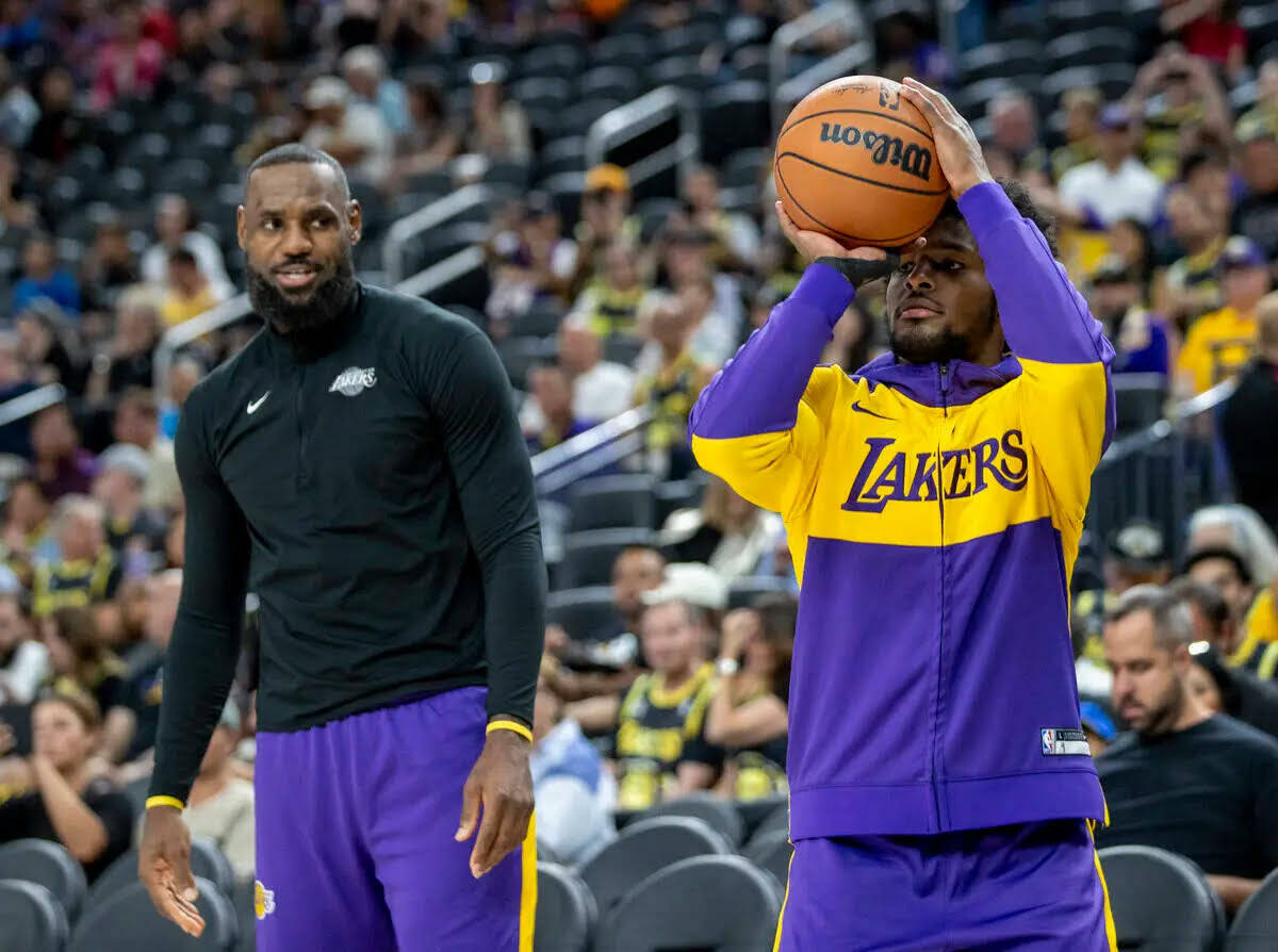 El forward de los Los Angeles Lakers LeBron James, a la izquierda, observa al guard Bronny Jame ...