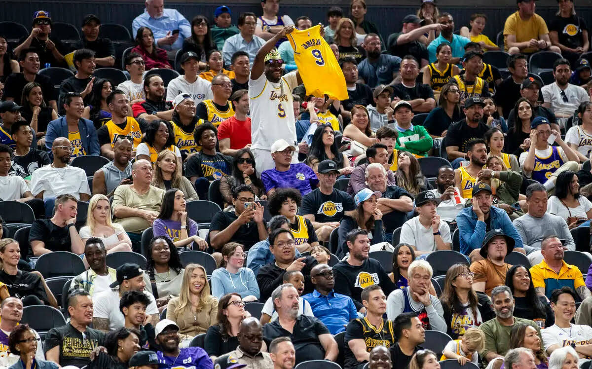 Un fan de los Los Angeles Lakers sostiene una camiseta de Bronny James Jr. mientras se escuchan ...