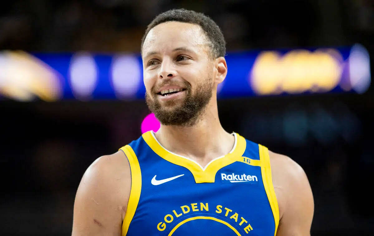 El guard de los Golden State Warriors Stephen Curry sonríe durante el partido de pretemporada ...