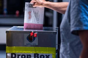 Un votante deposita su papeleta de voto por correo durante la jornada de elecciones primarias d ...