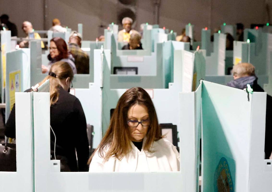 Personas emiten su voto durante la votación anticipada en el Thunderbird Family Sports Complex ...