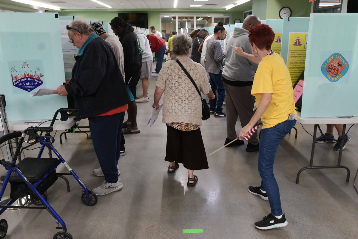 Una electora es dirigida a una cabina de votación disponible en el Silverado Ranch Community C ...