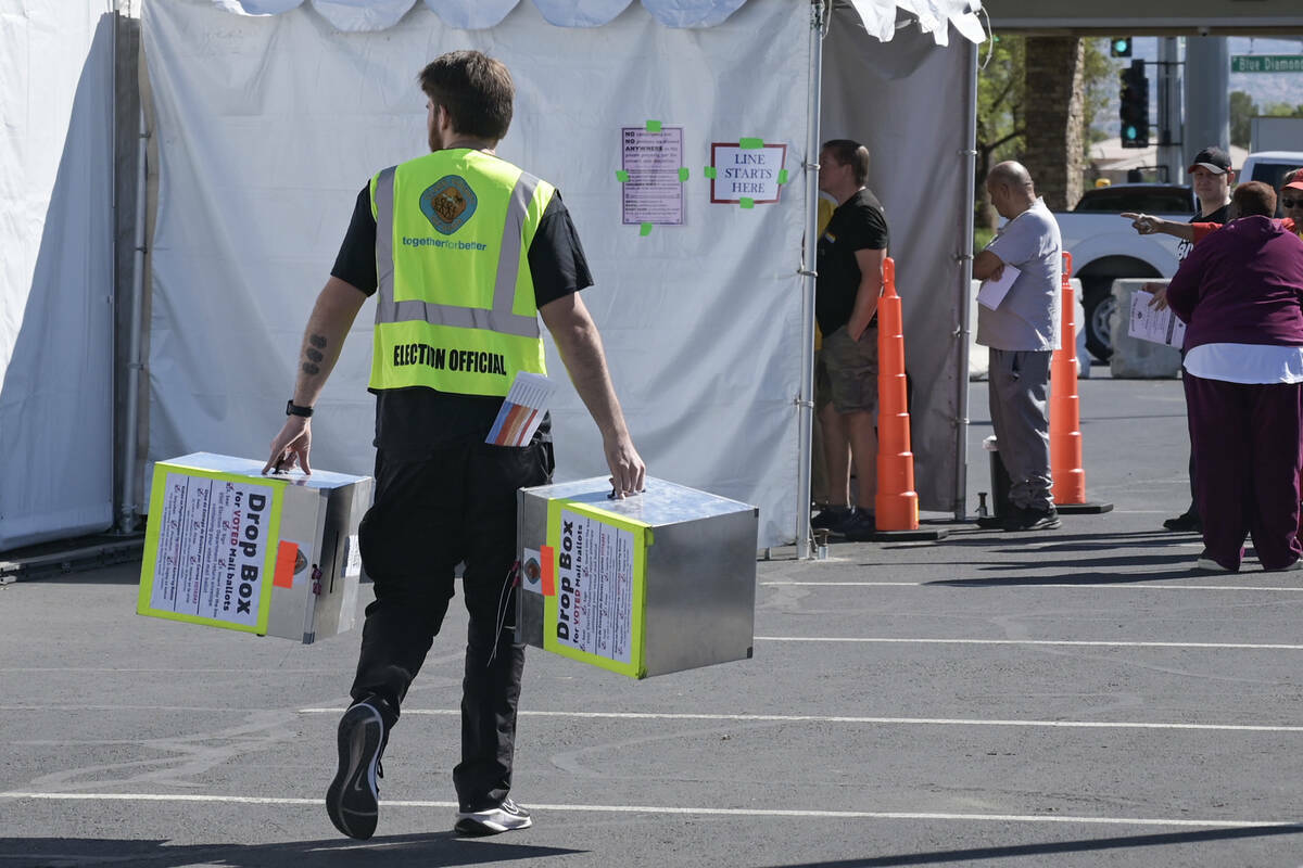 Un funcionario electoral lleva urnas vacías a un lugar de votación en Blue Diamond Road el pr ...