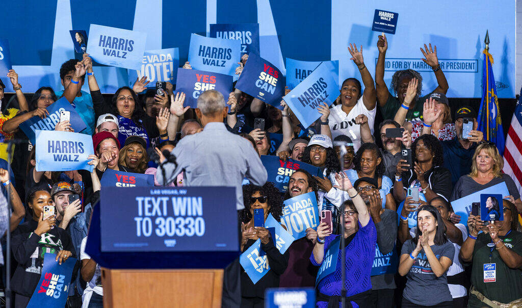 El expresidente Barack Obama saluda a la multitud detrás de él mientras habla en nombre de la ...