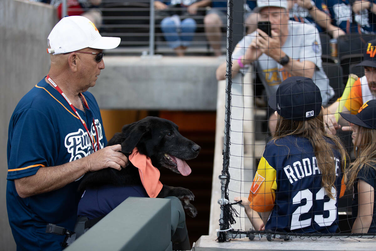 Fred Hassen y Finn the Bat Dog saludan a los fanáticos antes de un juego de las Ligas Menores ...