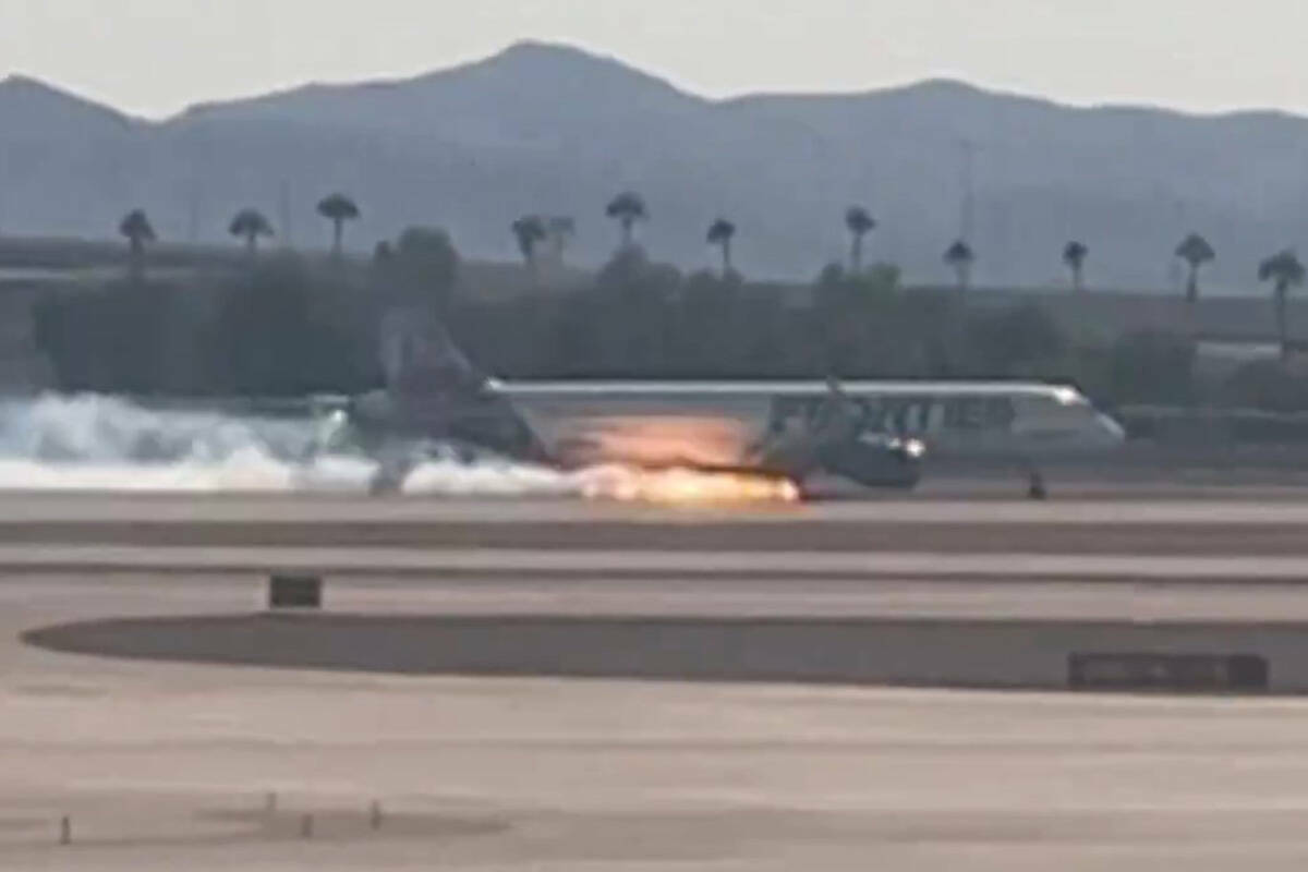 Vista de llamas y humo provenientes de un avión de Frontier Airlines que aterrizó en el Aerop ...