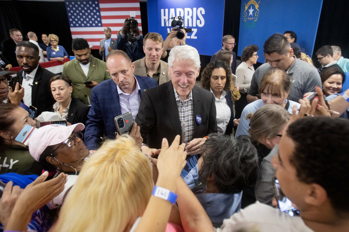 El expresidente Bill Clinton saluda a asistentes después de hablar durante una parada de campa ...