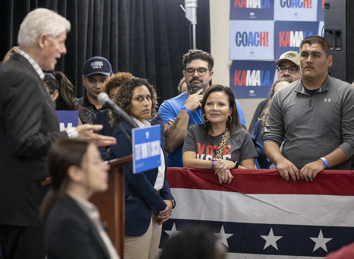 Asistentes escuchan hablar al expresidente Bill Clinton durante una parada de campaña a favor ...