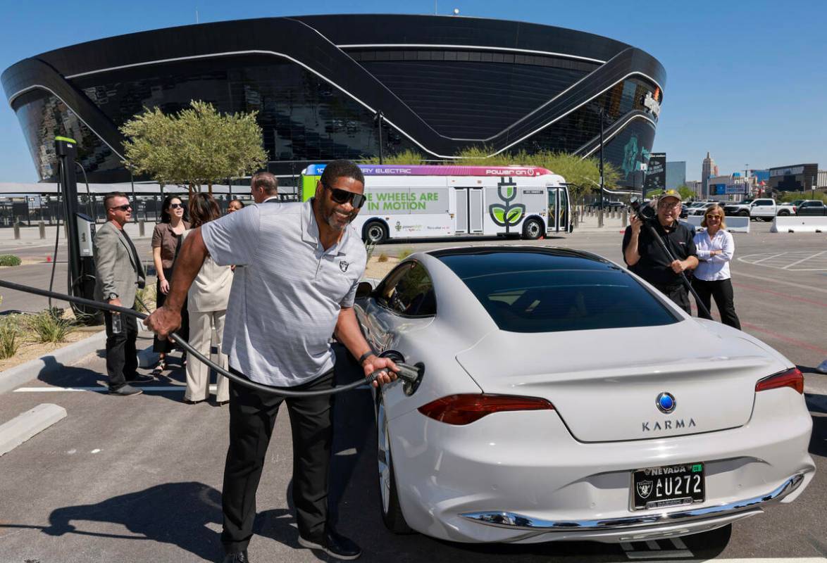 El exjugador de los Raiders Napoleon McCallum demuestra cómo enchufar un vehículo eléctrico ...