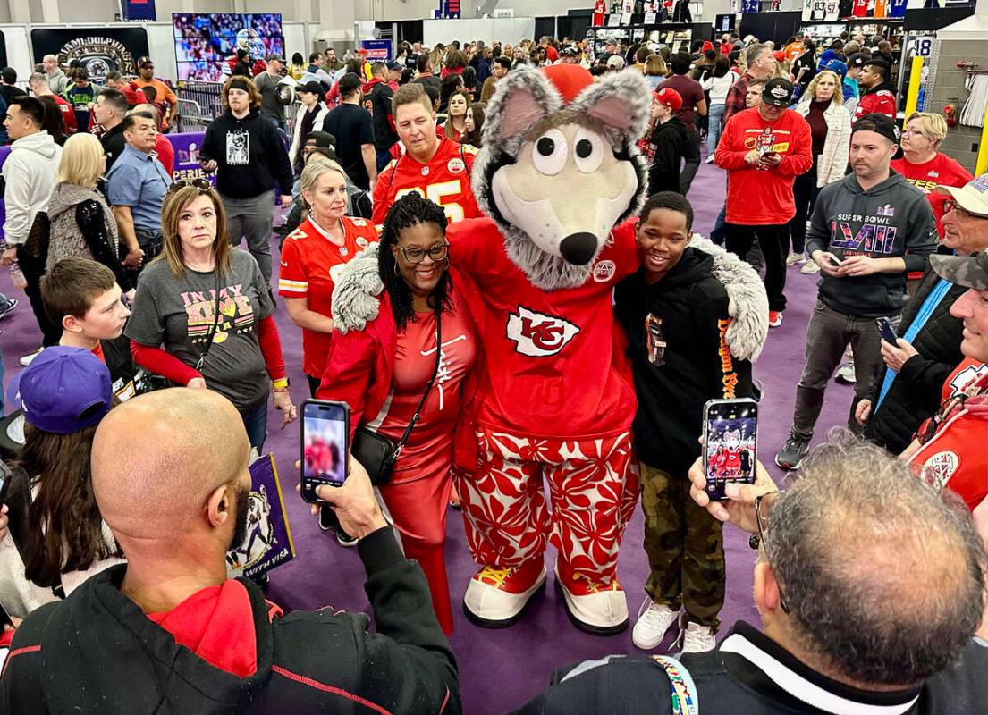 La mascota de los Kansas City Chiefs, K.C. Wolf, posa con los fanáticos de los Chiefs en el Su ...