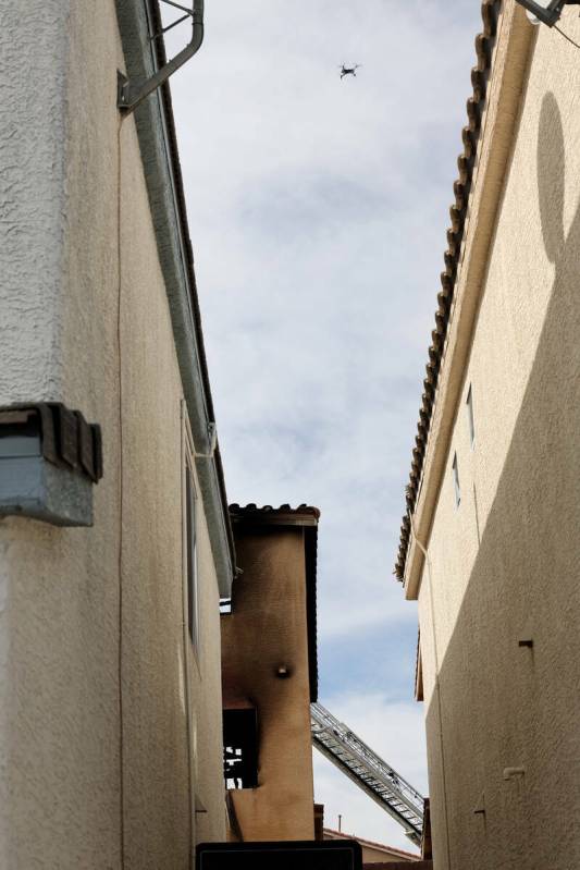 Un dron del Departamento de Policía Metropolitana sobrevuela los restos de una casa carbonizad ...