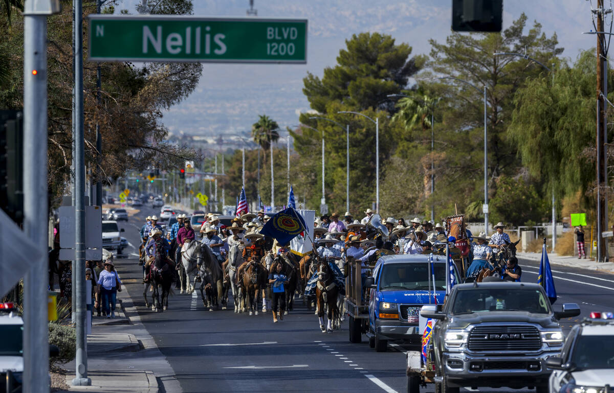 Los jinetes y participantes continúan su cabalgata por E. Washington Avenue durante una "Cabal ...