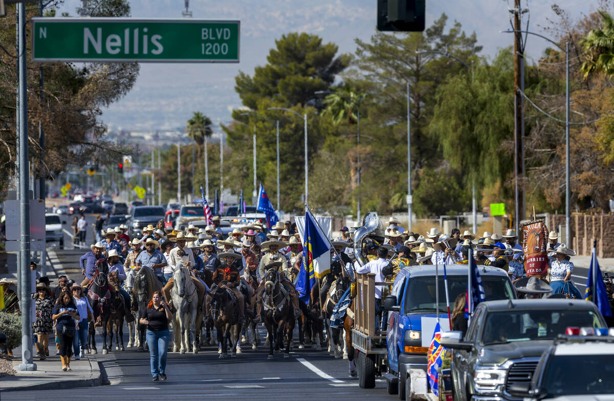 Los jinetes y participantes continúan su cabalgata por Harris Avenue durante una "Cabalgata a ...