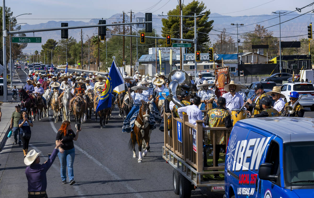 Los jinetes y participantes continúan su cabalgata por Harris Avenue durante una "Cabalgata a ...