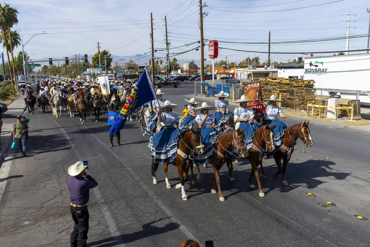 Los jinetes y participantes continúan su cabalgata por Harris Avenue durante una "Cabalgata a ...