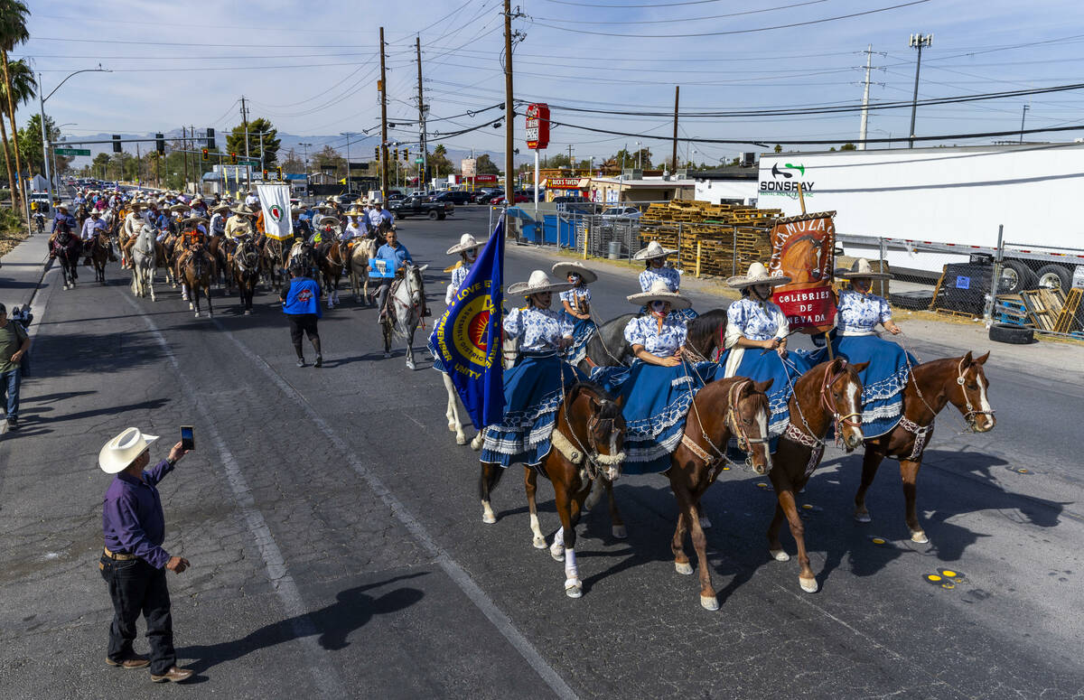 Los jinetes y participantes continúan su cabalgata por Harris Avenue durante una "Cabalgata a ...