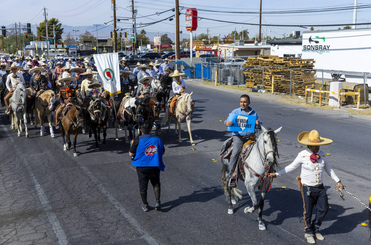 Los jinetes y participantes continúan su cabalgata por Harris Avenue durante una "Cabalgata a ...