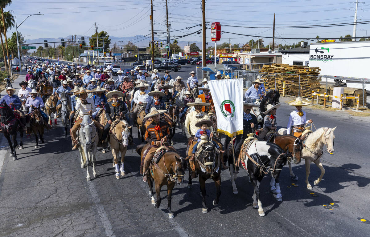 Los jinetes y participantes continúan su cabalgata por Harris Avenue durante una "Cabalgata a ...