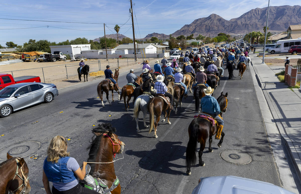 Los jinetes y participantes continúan su cabalgata por Harris Avenue durante una "Cabalgata a ...