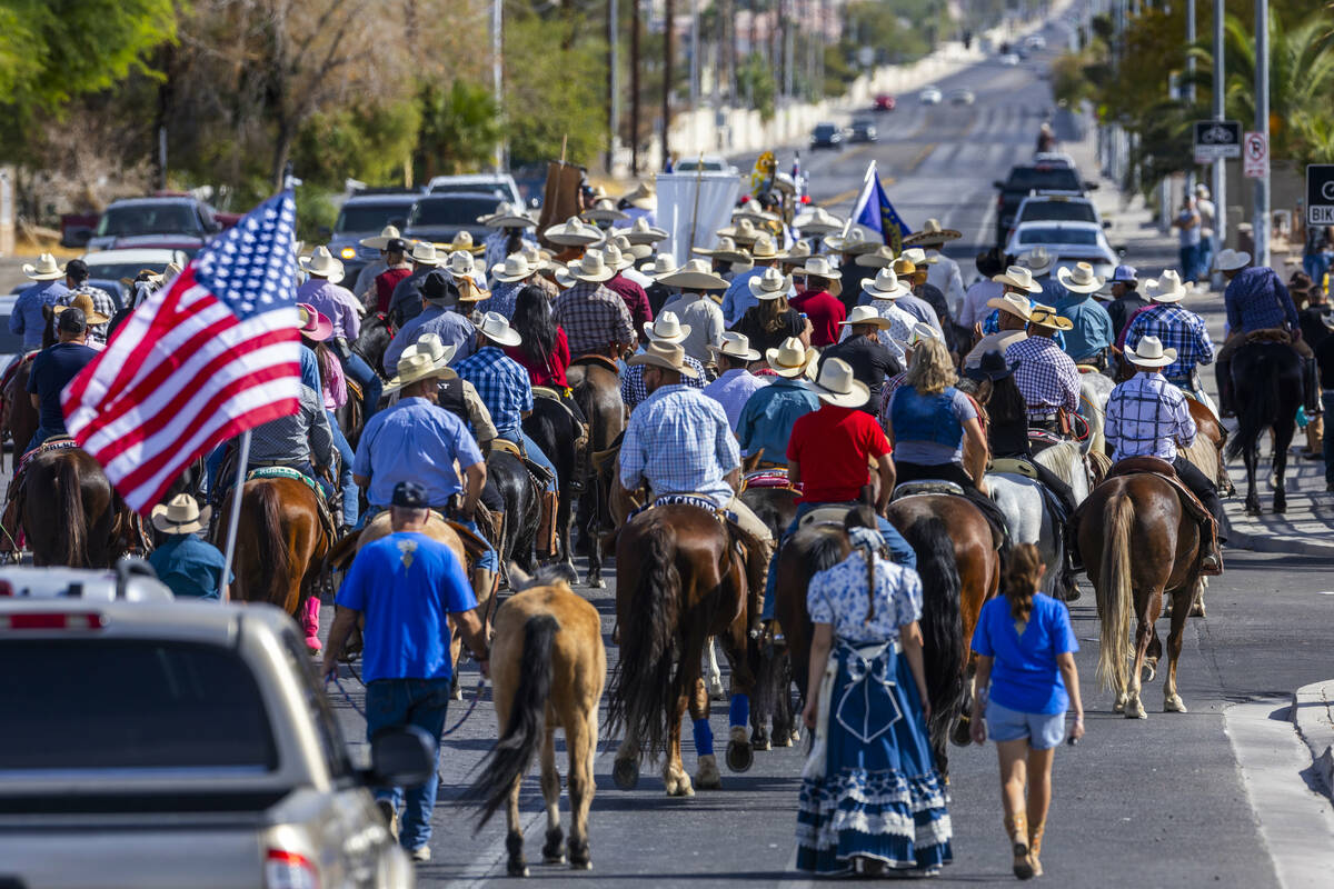 Los jinetes y participantes continúan su cabalgata por Harris Avenue durante una "Cabalgata a ...