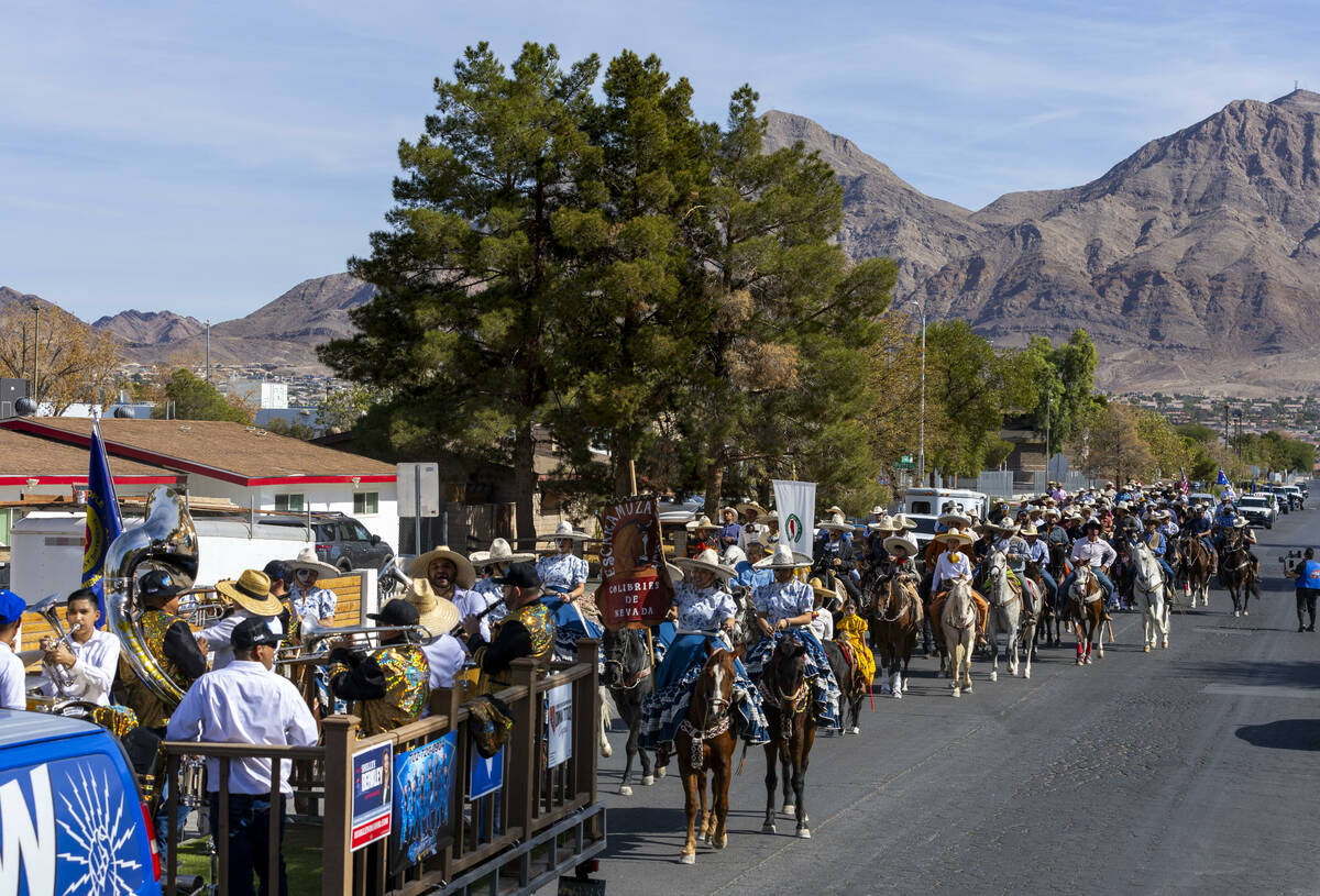 Los jinetes y participantes continúan su cabalgata por Harris Avenue durante una "Cabalgata a ...