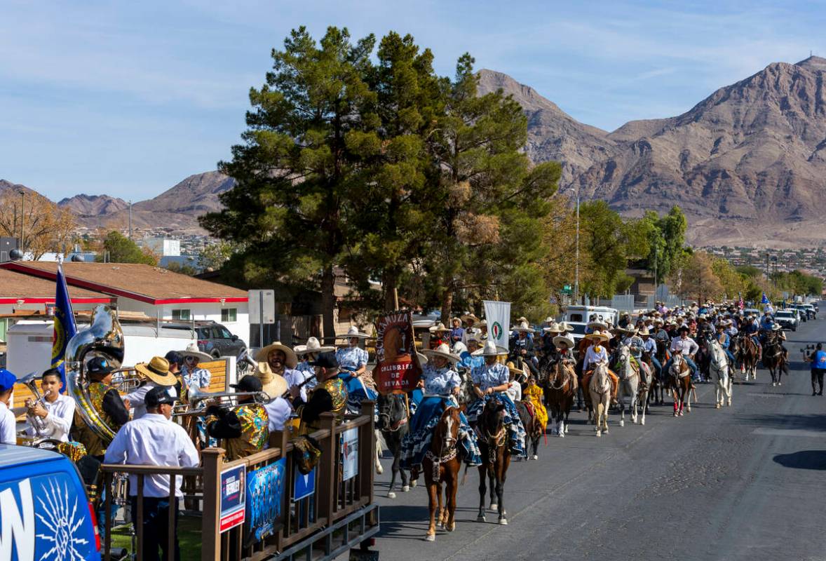 Los jinetes y participantes continúan su cabalgata por Harris Avenue durante una "Cabalgata a ...