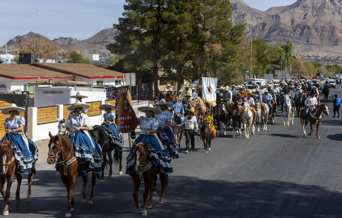 Los jinetes y participantes continúan su cabalgata por Harris Avenue durante una "Cabalgata a ...