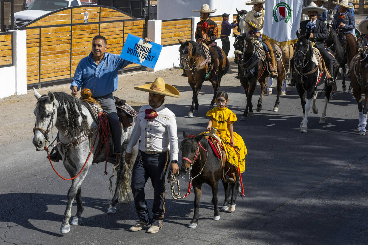 Los jinetes y participantes continúan su cabalgata por Harris Avenue durante una "Cabalgata a ...