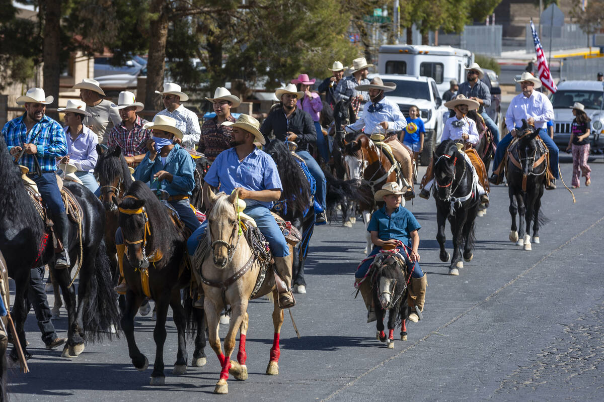 Los jinetes y participantes continúan su cabalgata por Harris Avenue durante una "Cabalgata a ...