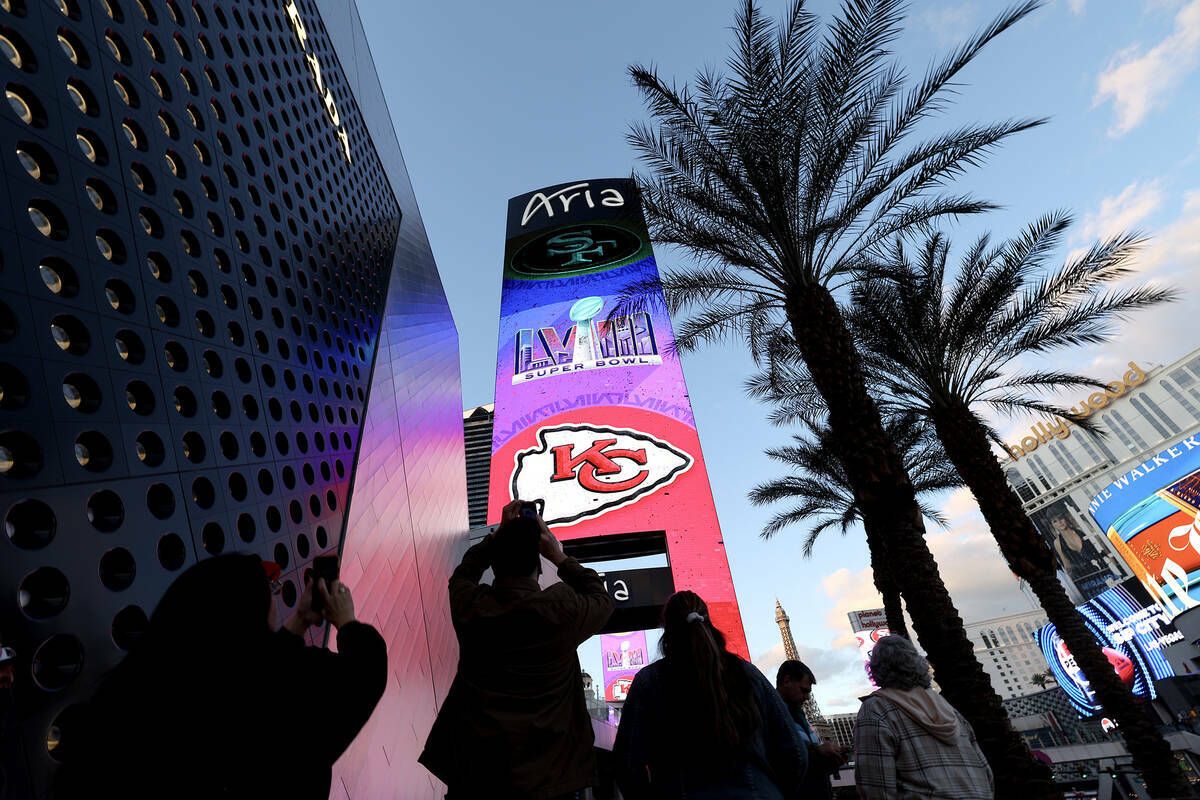 Fanáticos del fútbol americano fotografían una marquesina del Super Bowl en Aria, el sábado ...