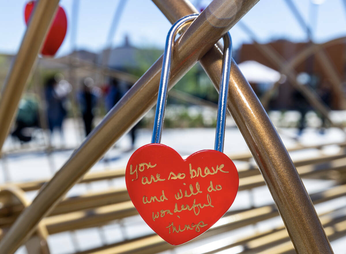 Un Candado de Amor está firmado con un mensaje y colgado en una escultura de corazón durante ...