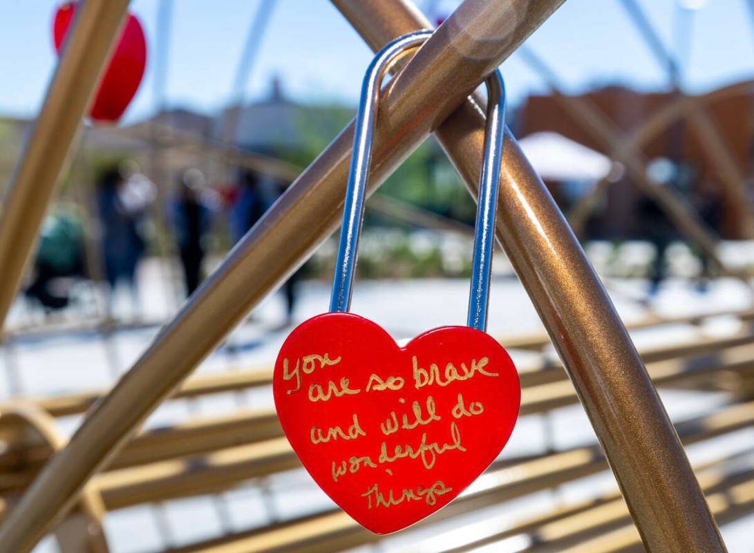 Un Candado de Amor está firmado con un mensaje y colgado en una escultura de corazón durante ...